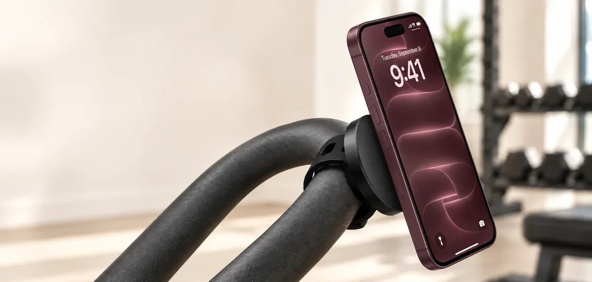 Orange phone attached flush to a black magnetic disc, with the flexible strap secured around a curved gym handle.