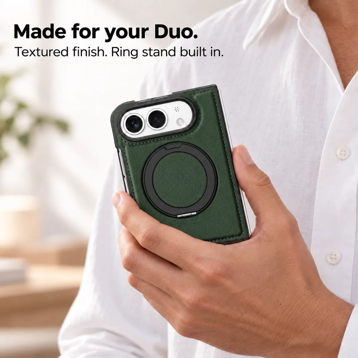 Hand holding a textured synthetic leather folding phone case with the ring stand folded flat. #color_Forest Green