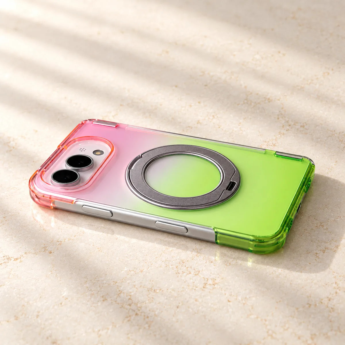 Close view of a pink-to-green translucent phone case with a silver ring folded against the back.